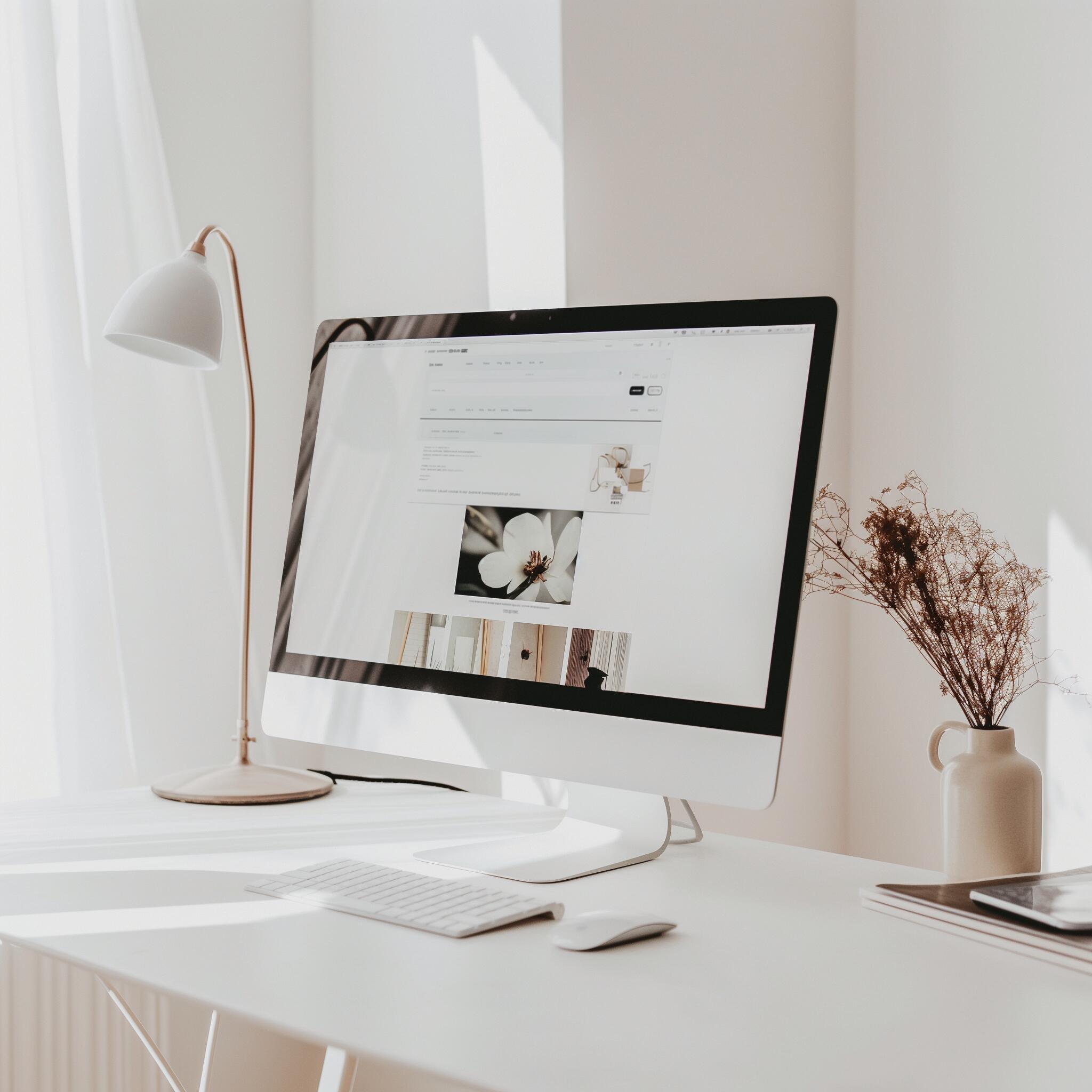 Modern workspace showcasing a desktop computer displaying a consulting agency’s website, symbolizing innovative marketing and social media strategies. A minimalist desk setup with natural light highlights the agency's focus on clarity, creativity, and professionalism.